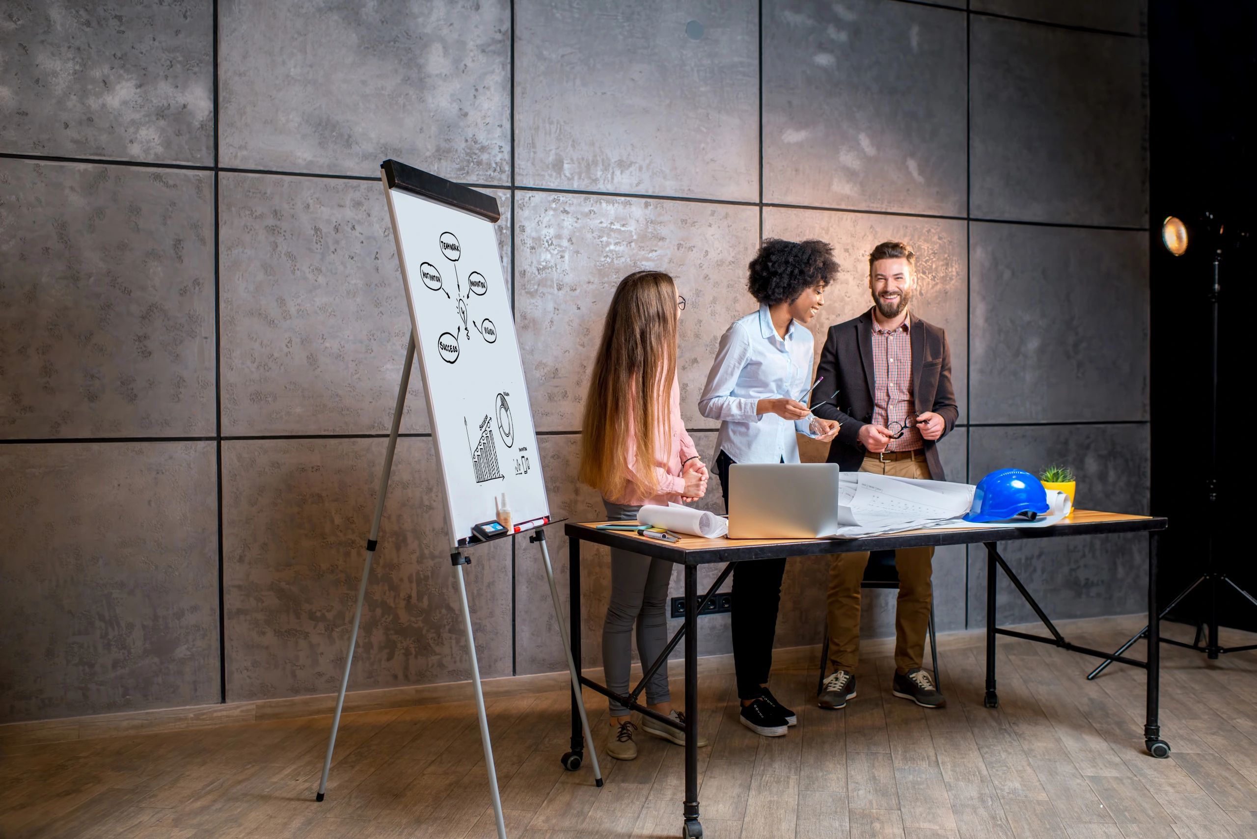 Team of professionals collaborating over architectural plans in an office